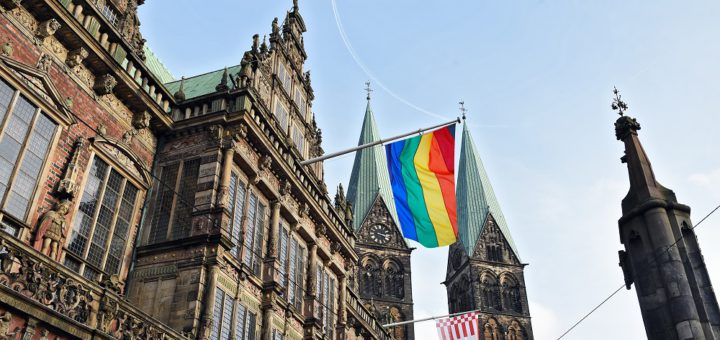 Die Fotomontage zeigt, wie das Rathaus mit Regenbogenflagge aussehen würde. Montage: Schlie