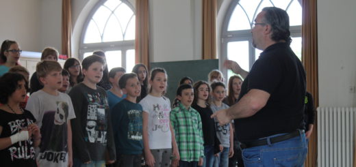 Verstehen sich schon während der Proben bestens: Die Kinder von „ThinkMusic!“ und Juilo Fernández (r.) von der Hochschule Bremen. Foto: Waalkes