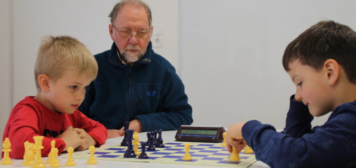 Leon und Filipp (v.l., beide sechs Jahre alt) spielen Schach wie zwei ganz Große. Wilfried Buchterkirche (m.) bietet zweimal wöchentlich ehrenamtlich die Schachgruppe in der KiTa Flintacker an. Foto: Füller