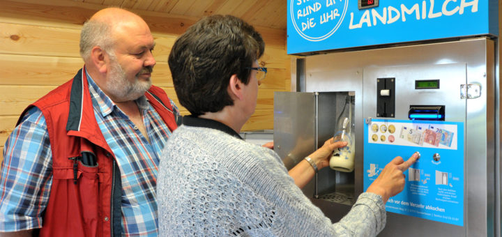 Rainer und Herma Fortmann demonstrieren die Funktionsweise ihrer Milchtankstelle: Gereinigtes Gefäß in die Box, Knopf gedrückt halten – und schon kommt die frische Milch geflossen. Foto: Konczak