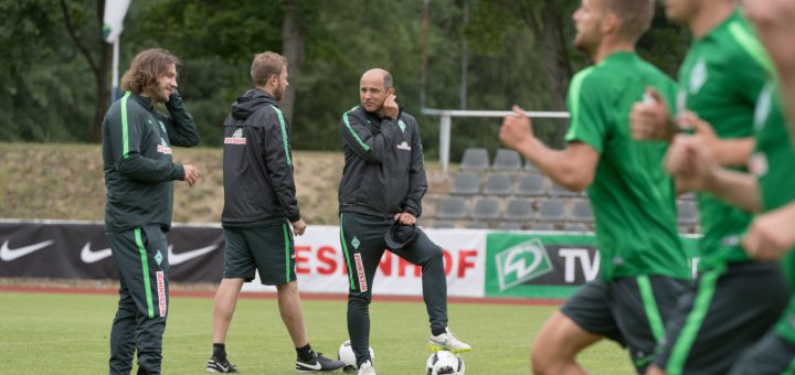 Die Spieler rennen, das Trainerteam um Chefcoach Viktor Skripnik (M.) und seinen Assistenten Torsten Frings (l.) und Florian Kohfeldt bespricht sich. Foto: Nordphoto