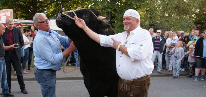 Rinderzüchter Hermann Maack und das DJ Ötzi-Double Kay Christiansen mit dem Welsh-Black-Bullen "Elten", der stolze 1.296 Kilogramm auf die Waage brachte. Foto: Möller