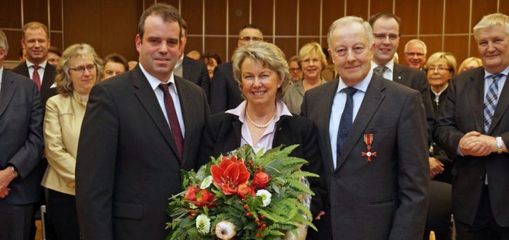 Bundesverdienstkreuzträger Wilhelm Hogrefe mit Ehefrau Renate und Landrat Peter Bohlmann vor Gästen bei seiner EhrungFoto: Bruns