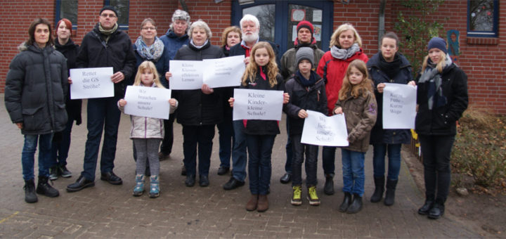 Kathrin Eilers (links) und Detlev Hansing (Achter von rechts) protestieren gemeinsam mit anderen Eltern, Kindern und Anwohnern gegen eine Schließung der Grundschule in Ströhe. Foto: Möller