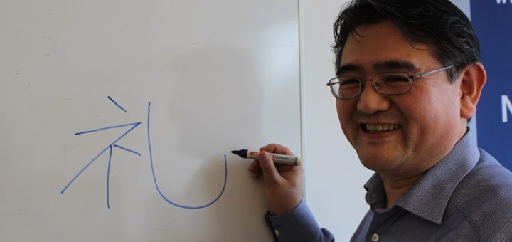 Hide Tsukamoto zeichnet ein japanisches Schriftzeichen, Kanji genannt, an die Tafel. Es bedeutet sinngemäß „Höflichkeit“. Foto: Harm