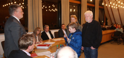 Der Schüler Mike Fettrau überreichte vor Sitzungsbeginn eine Liste mit 504 Unterschriften gegen die Schulschließung an Samgemeindebürgermeister Reinhard Kock. Foto: Möller
