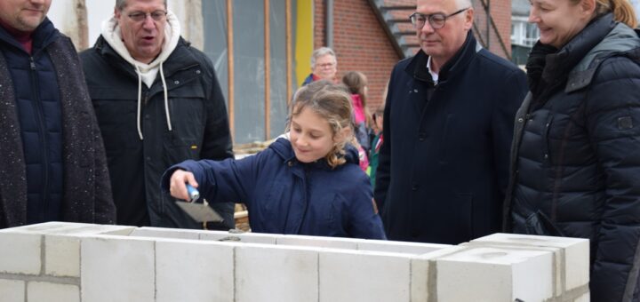 Der Schülerin Mayleen kam die Ehre zuteil, die Zeitkapsel in das neue Gebäude einzumauern. Foto: Utke