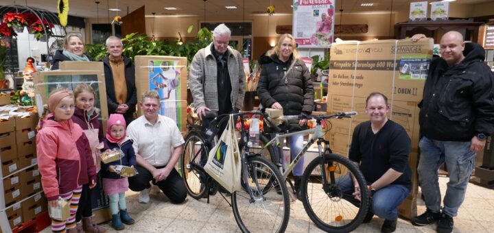 Im Marktkauf-Einkaufsmarkt übergaben Stefan Molkentin (2.von rechts) von der Klosterholz-Tombola zusammen mit Marktleiter Mischa Ludwig (Mitte, kniend ) die hier gespendeten Gewinne an die Loskäufer. Foto: Fricke