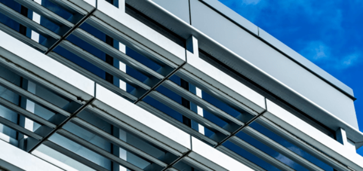 Maßarbeit aus Metall: Warum Alu-Profile die Basis moderner Konstruktionen sind. Bild: https://unsplash.com/de/fotos/weissbetongebaude-tagsuber-EFoTVFPH0sU