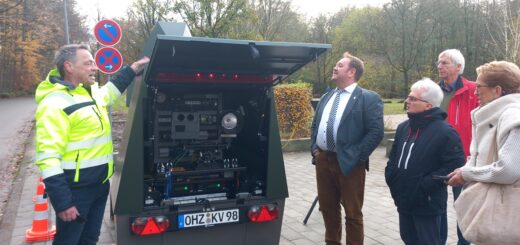 Ulf Breden (links), Leiter der Kommunalen Verkehrsüberwachung des Landkreises, stellte dem Verkehrsausschuss vor dem Kreishaus den neuen Blitzer-Anhänger vor. Foto: Roskamp